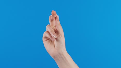 female hand with snapping fingers on blue screen background.