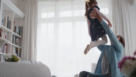 little-girl-jumping-into-fathers-arms-happy-dad-gently-catching-his-daughter-enjoying-playful-game-with-child-at-home-4k