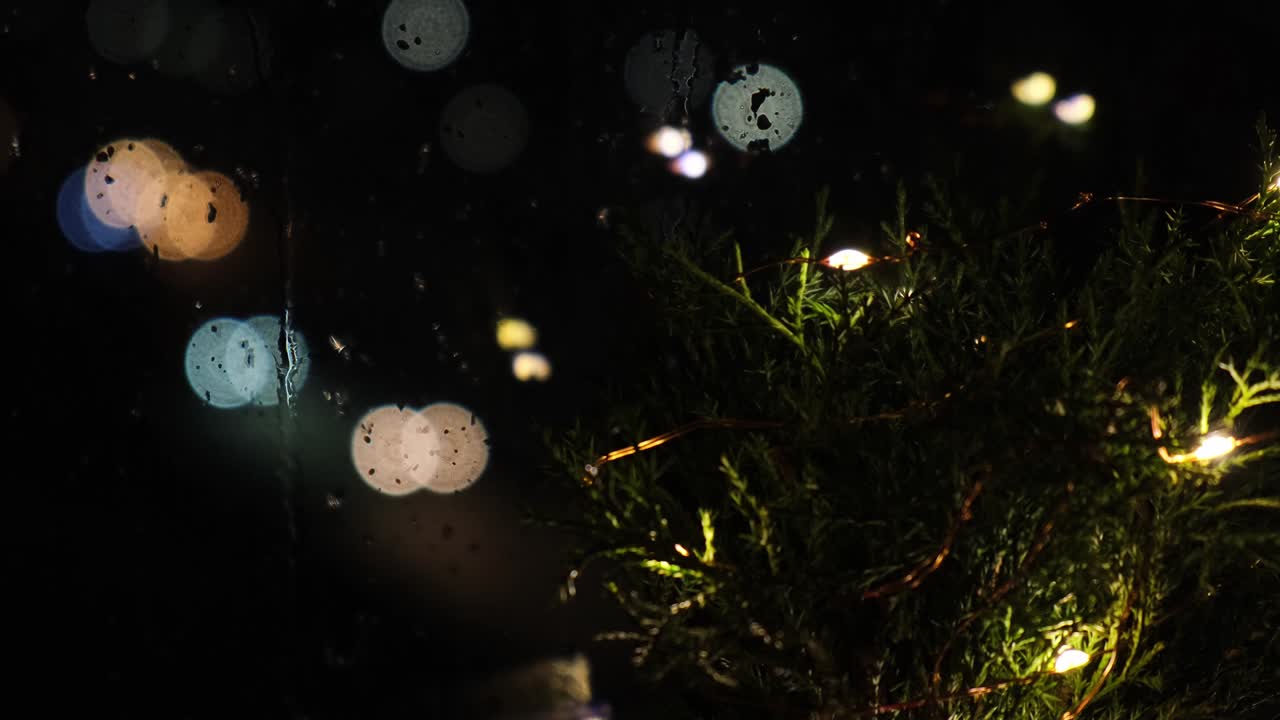 夜のリビングルームに飾られたエコクリスマスツリー、背景には車のボケライト。ゼロウェイストの飾り付け。ループビデオ、冬のホリデーの雰囲気