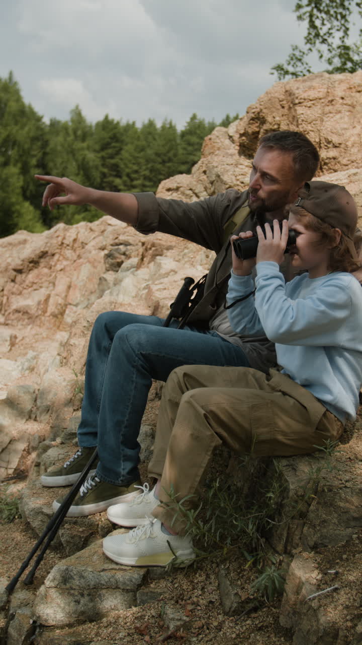 Father and son hiking and exploring with binoculars