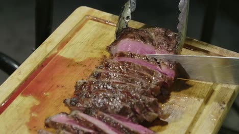 cutting grilled juicy steak on table