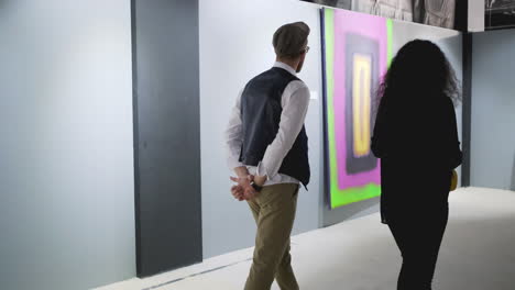 pareja viendo arte moderno en una sala de exposiciones