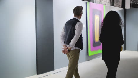 couple viewing modern art in an exhibition hall