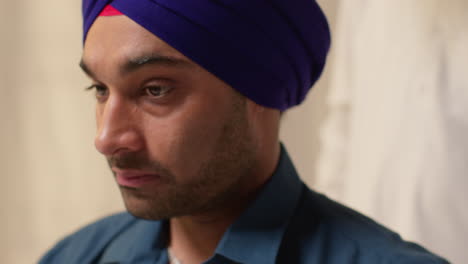 Close-Up-Studio-Shot-Of-Two-Sikh-Men-Using-Salai-Needle-When-Putting-On-Turban-Against-Plain-Background-1