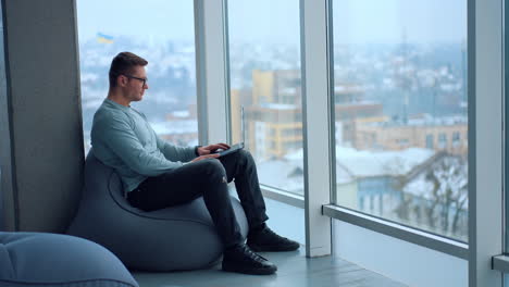 man working on laptop in a modern office space