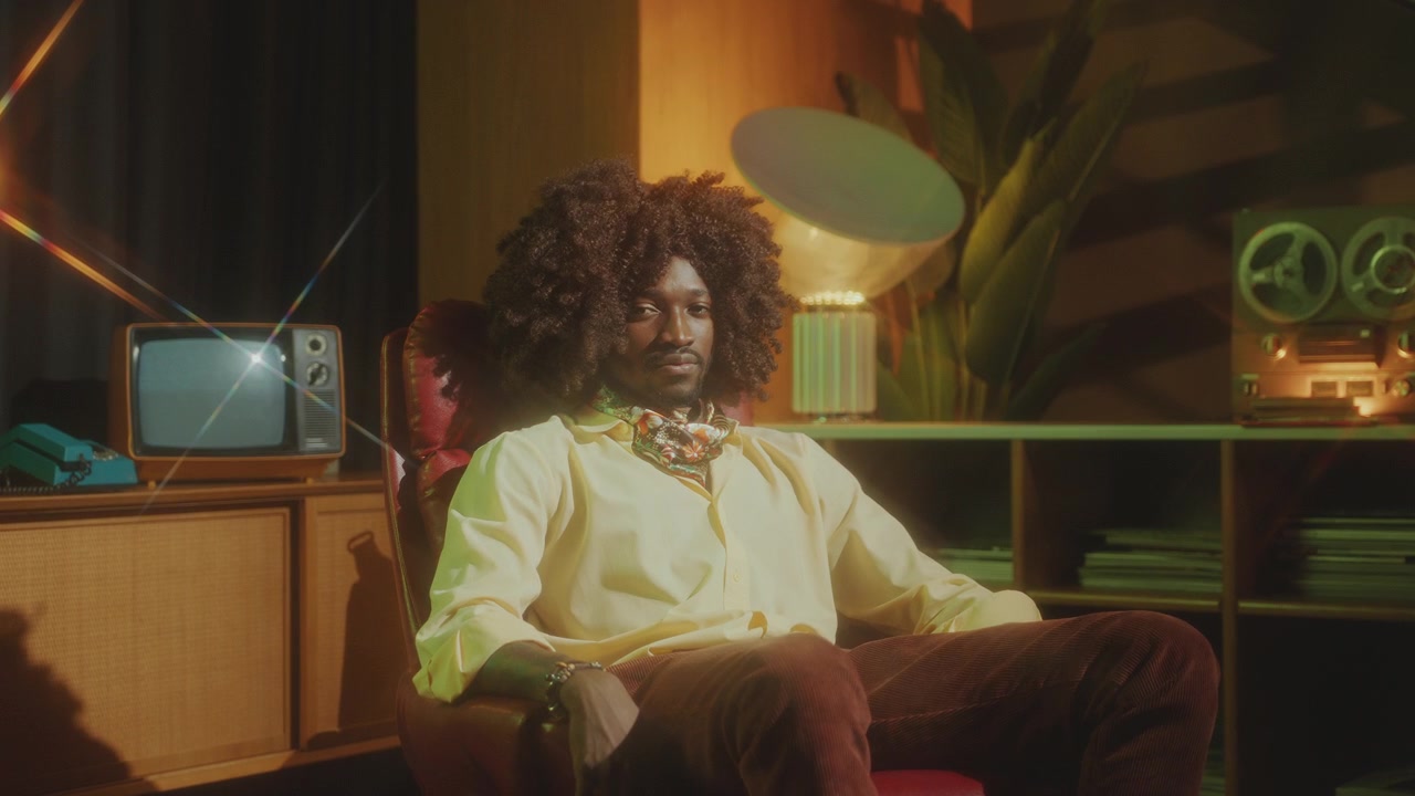 Flot afroamerikansk mand i retro-outfit poserer i et vintage studie