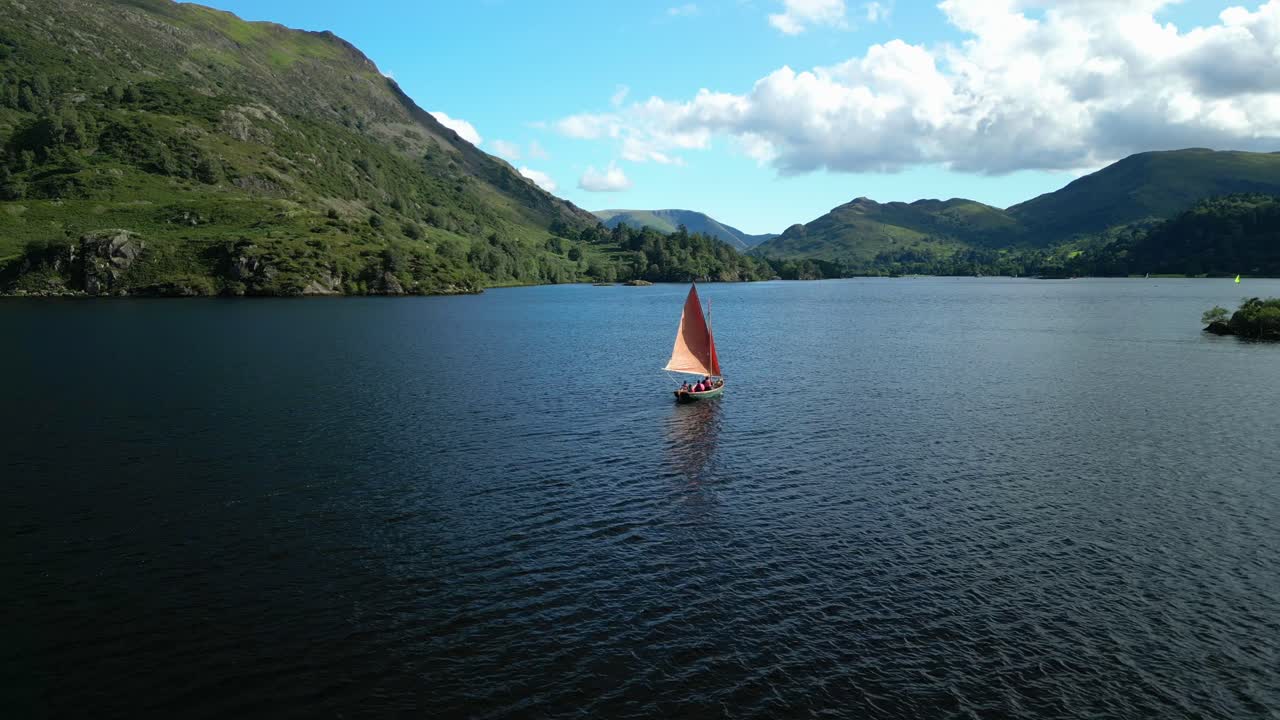 Lille yacht på mørk sø omgivet af skovklædte stejle bjergsider på en lys sommerdag