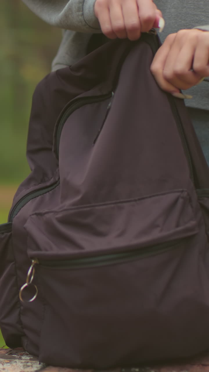 평화로운 숲을 고 있는 형제자매의 클로즈업, 각자가 배을 들고, 그들은 주머니를 떨어뜨리기 위해 멈추고, 한 명이 물건을 가져오기 위해 자신의 주머니를 열기 시작합니다.