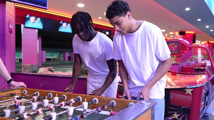 Two young men playing foosball in an arcade
