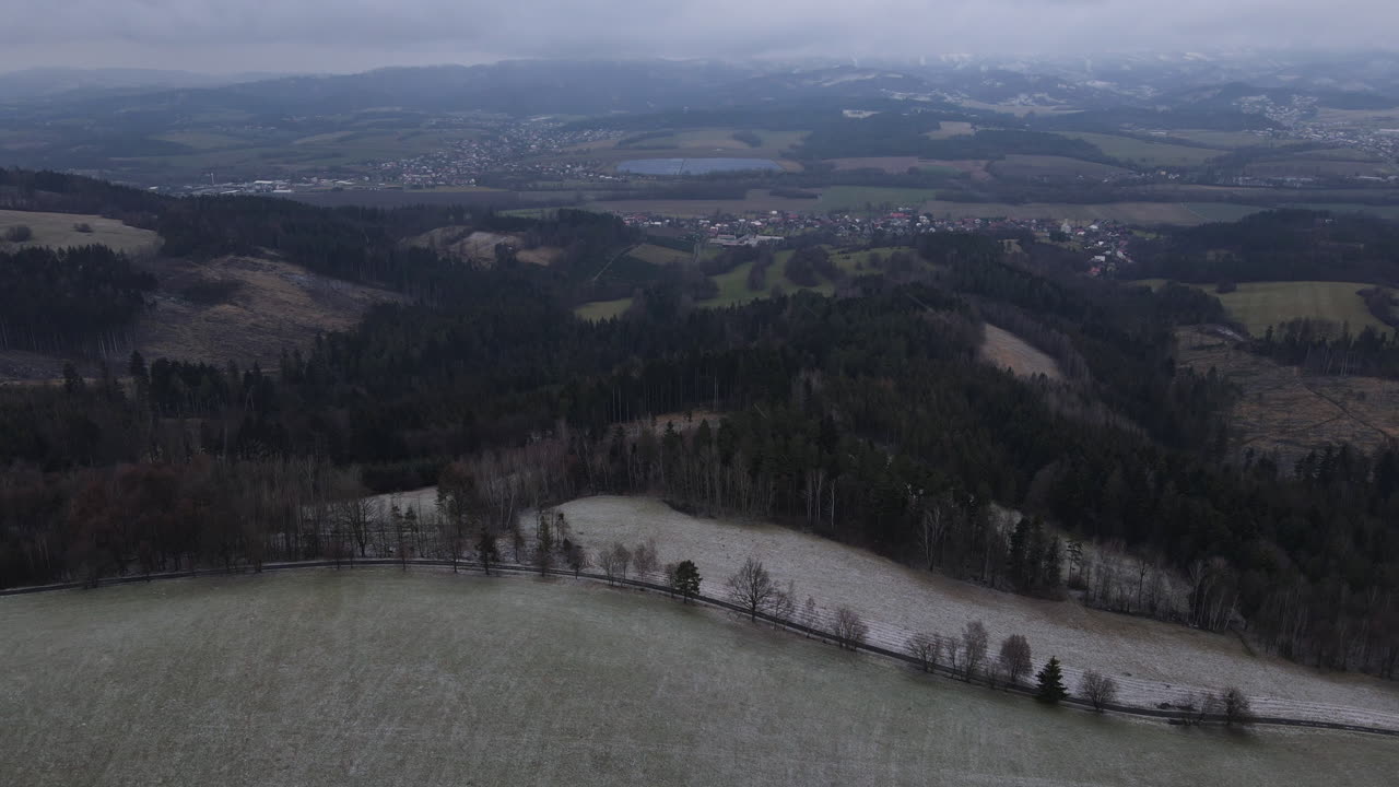 눈이 내리기 시작하는 동안 나무 사이로 이어지는 길과 주변 사물을 볼 수 있는 시골 위의 비행