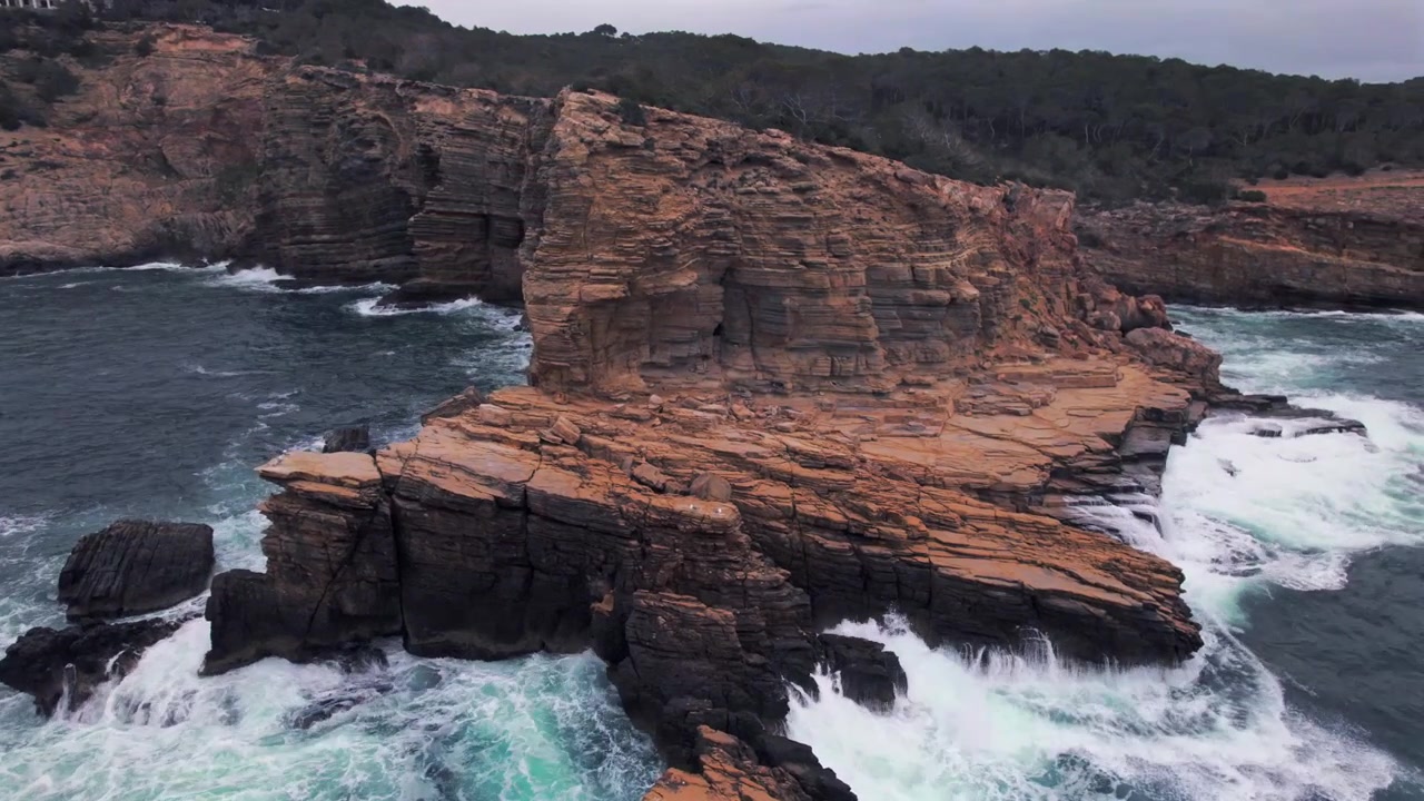 4K drone aerial view of Sa Punta Galera in Ibiza, Spain. Dramatic rocky coastline, crystal-clear Mediterranean waters and distinctive flat rock formations create a spectacular natural landscape.