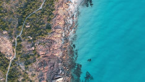 Aerial-drone-top-down-static-footage-of-castle-rock,-walkway-next-to-the-ocean,-Western-Australia