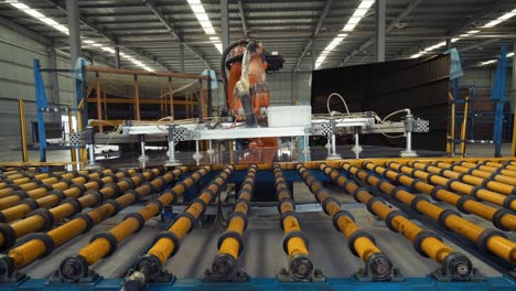 robotic arms automatically take flat glass from a conveyor line and place on a rack