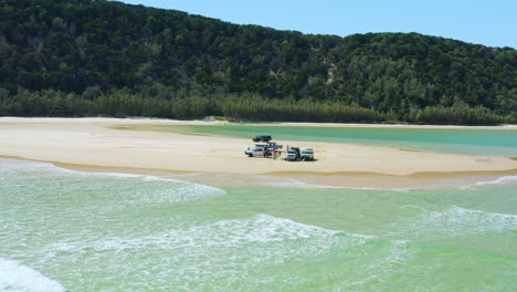 Drone-Aéreo-4k-Sobre-Autos-Con-Instalación-De-Campamento-En-La-Playa-De-Arena-Junto-Al-Océano,-Australia