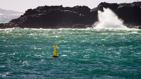 angry ocean with a yellow buoy in slow motion