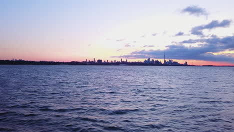 flying across lake ontario at dawn with a view of the downtown toronto skyline