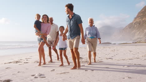 Familie-Mit-Mehreren-Generationen-Im-Sommerurlaub,-Die-Am-Strand-Entlang-Spaziert