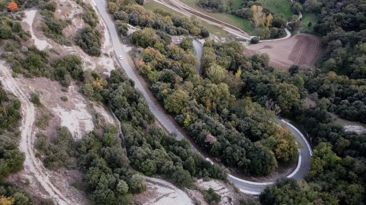 vistas aéreas de una carretera de montaña curva con un coche al atardecer en el otoño de los pirineos
