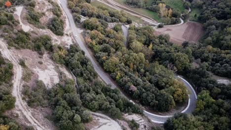 Aerial-views-of-a-curvy-mountain-road-with-a-car-at-sunset-in-the-autumn-of-the-pyrenees