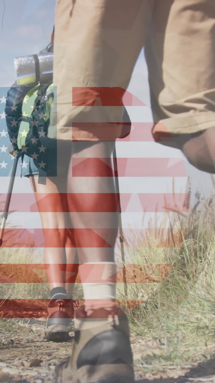 animación de la bandera estadounidense sobre una pareja diversa caminando en las montañas