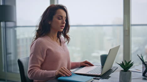mujer de negocios abriendo la tapa de la computadora portátil en el lugar de trabajo. mujer leyendo un cuaderno