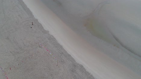 aerial view of a beach with people and flags