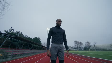 man running on a track in a stadium