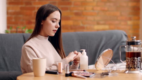 woman applying hand lotion before makeup routine