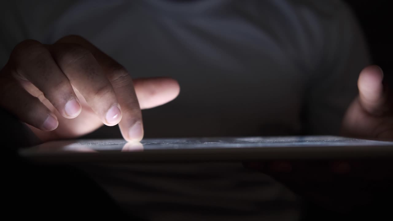 persona que usa una tableta por la noche