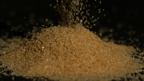 Golden-sugar-pouring-on-black-background