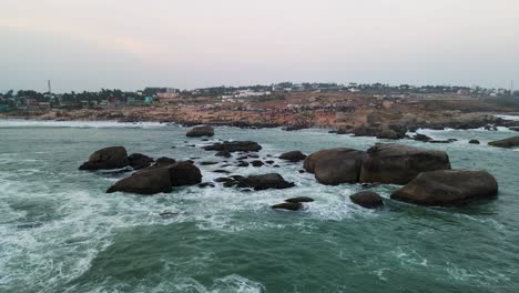 aerial drone shot revealing kanyakumari’s dynamic cityscape and tranquil ocean during the golden sunset.