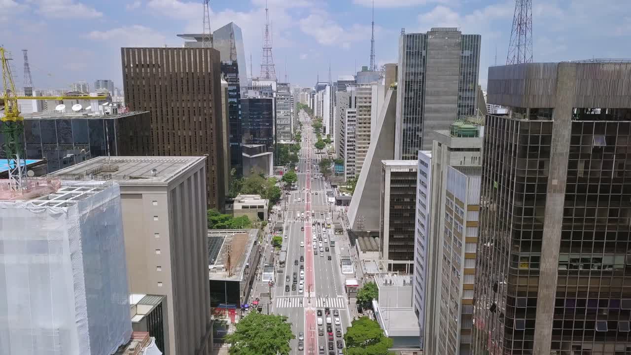 Sao Paolo financial street Avenida Paulista on a busy day with traffic and working people- ascending aerial drone shot made in Brazil