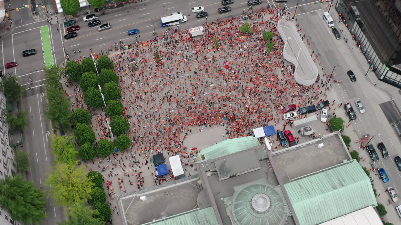많은 원주민 시위대가 아래에 모여 틸트 공중을 뒤로 당깁니다.