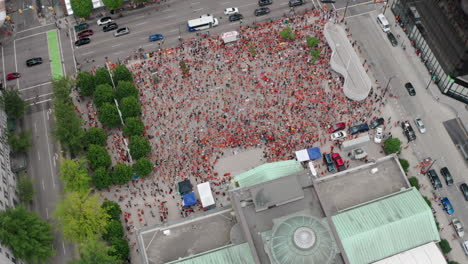 huge crowd of native protesters assemble below, pull back tilt aerial