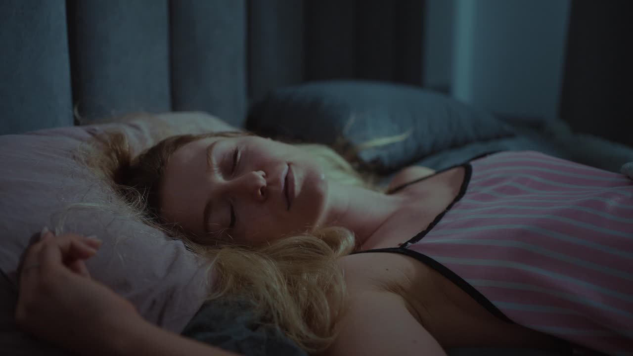 mujer durmiendo en la cama por la noche