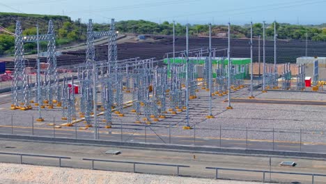 power plant station construction in front of large solar panel farm park on dominican republic