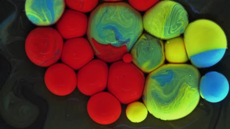 colorful bubbles. abstract red, yellow, blue, green mixture on a black background. artistic color paint background.