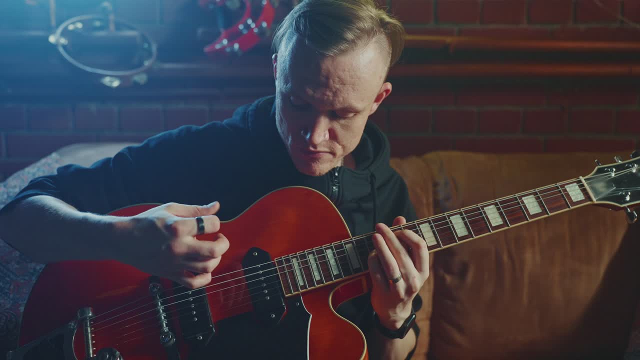 Man Playing a Red Electric Guitar at Home