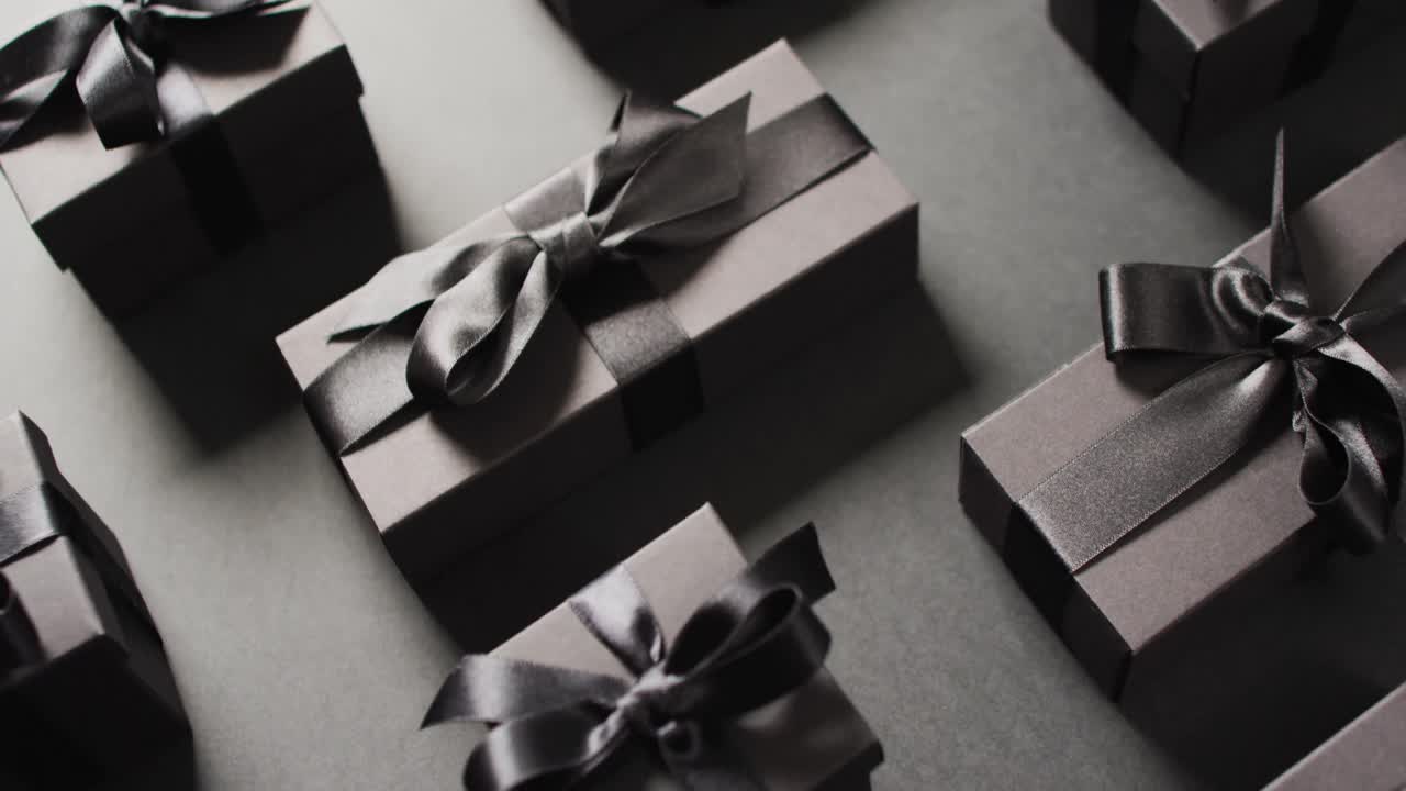 черные подарочные коробки, привязанные черными лентами на черном фоне