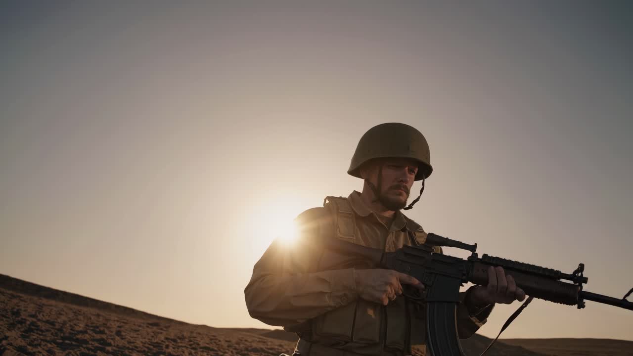 A soldier in uniform holds a rifle at sunset, captured from a low-angle