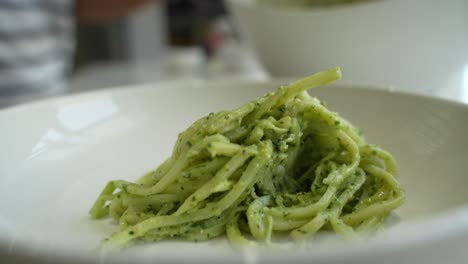 closeup shot of zucchini pasta served on white plate.