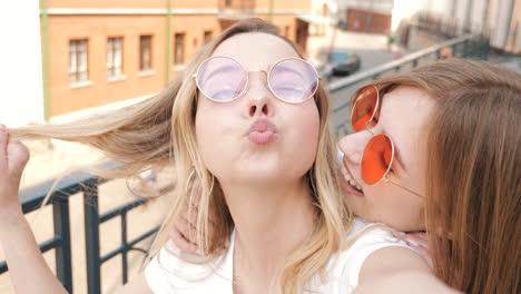 two happy friends taking a selfie in the city