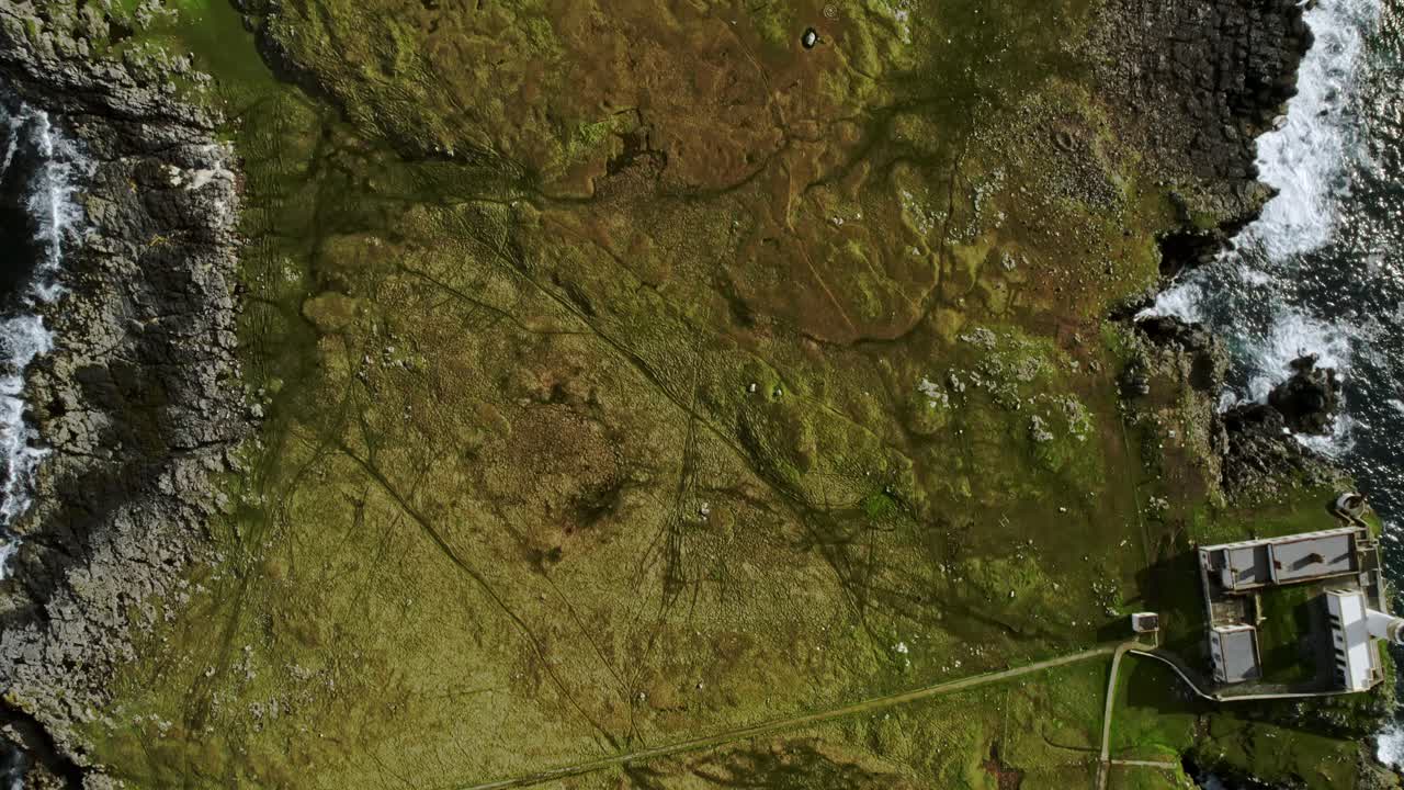 olas rompiendo contra rocas drone volando sobre la península de neist point, escocia