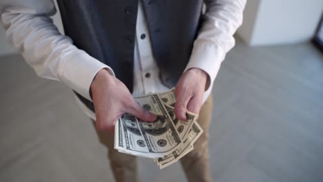 joven empleado cuenta el dinero después de recibir el salario en el trabajo