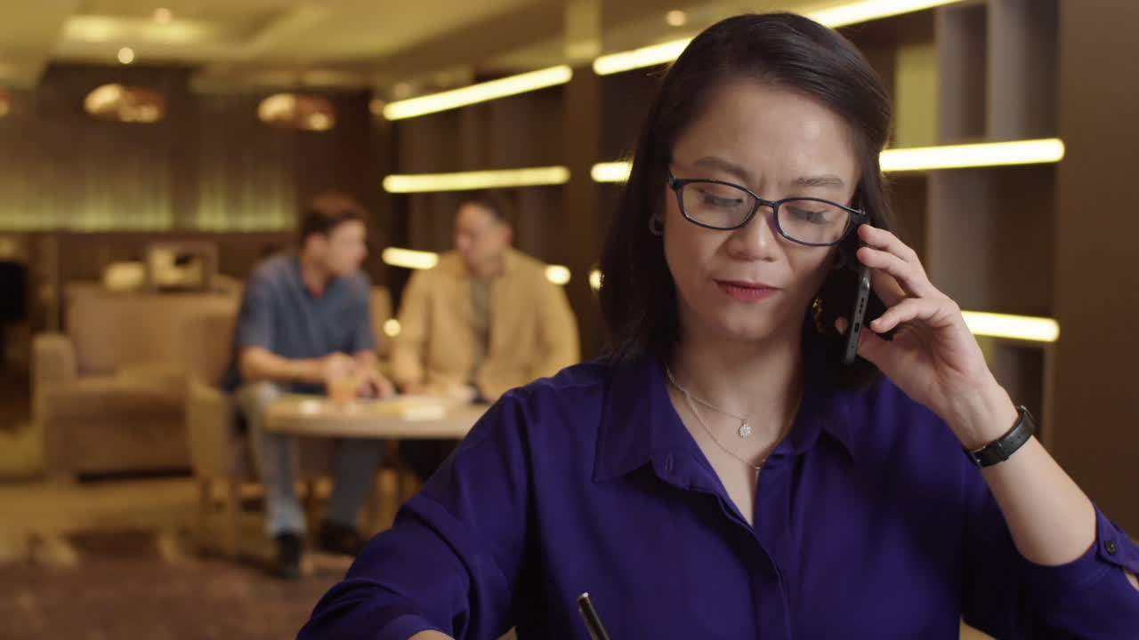 Female Manager Calling Client while Signing Document