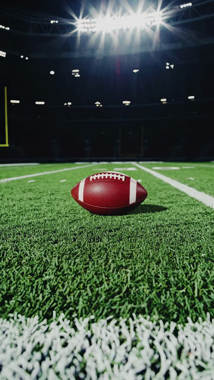 Inquadratura drammatica dal basso di un pallone da calcio su un campo da stadio sotto luci intense