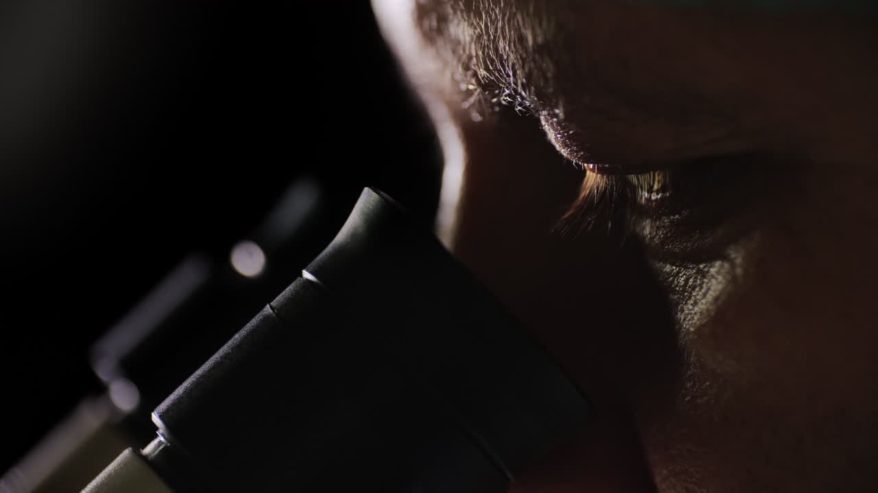 vista lateral de un científico que trabaja con un microscopio en el laboratorio 1