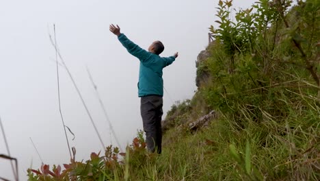 man alone at mountain rock with white mist background from flat angle