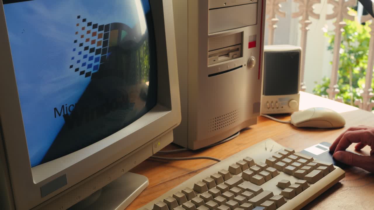 BARCELONA, SPAIN, 10 JUNE 2025. Man working and gaming on retro computer PC, IT engineer with vintage computer at home, using old fashion technology, close up of retro setup.