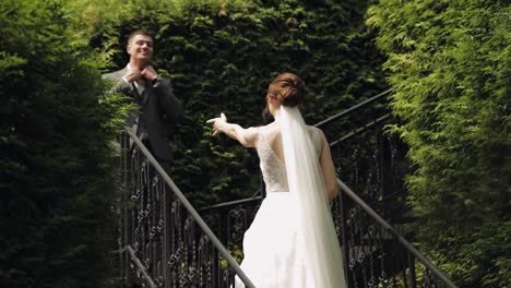 Newlyweds,-caucasian-groom-with-bride-stay-on-stairs-in-park,-wedding-couple,-man-and-woman-in-love